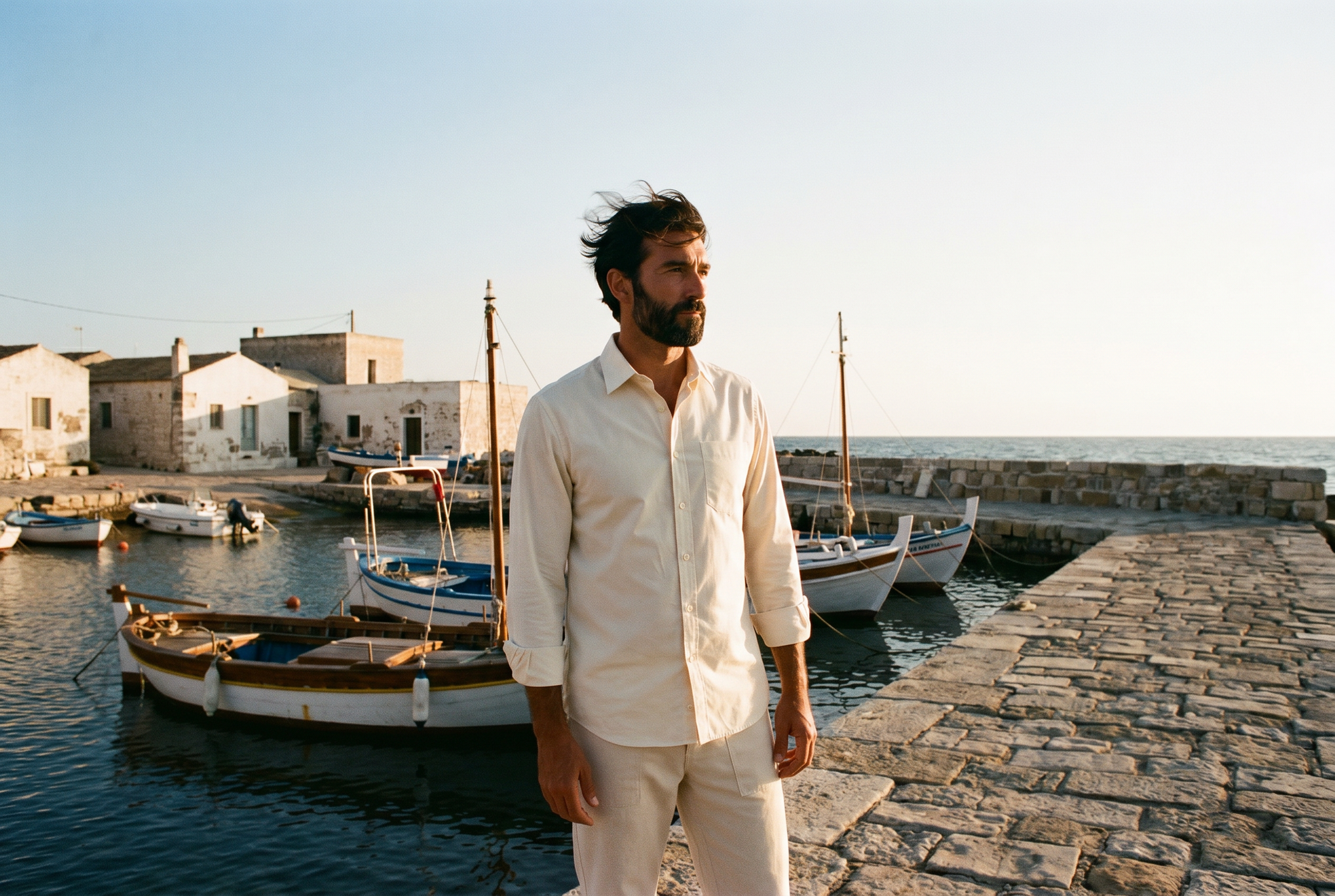 Hombre en el espigón de un puerto al atardecer